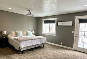 Bedroom featuring multiple windows, carpet floors, a textured ceiling, recessed lighting, and access to outside