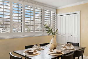 Dining room featuring a textured wall and crown molding