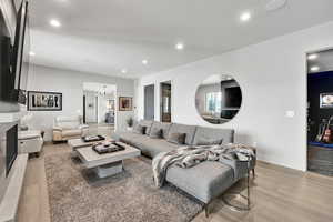 Living area with light wood-type flooring, recessed lighting, and a chandelier