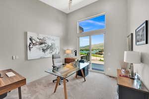 Office area featuring carpet floors and a high ceiling