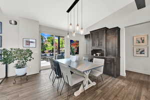 Dining area featuring wood finished floors and vaulted ceiling