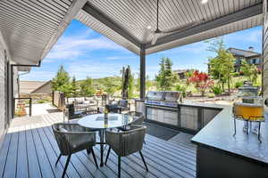 Deck with outdoor dining space, exterior kitchen, and outdoor lounge area