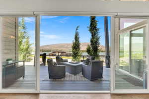 Doorway to outside with wood finished floors, a water and mountain view, and a residential view