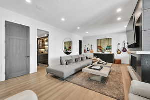 Living area with recessed lighting and light wood finished floors