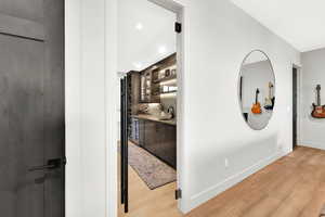 Hallway with light wood-style flooring, recessed lighting, and beverage cooler