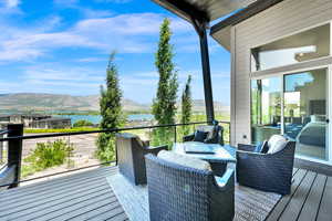 Wooden terrace featuring a water and mountain view