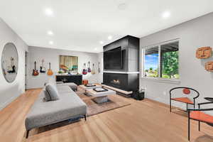 Living area featuring light wood-style floors, recessed lighting, and a fireplace