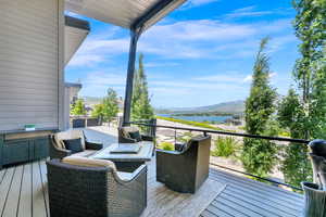 Wooden terrace featuring a water and mountain view and outdoor lounge area
