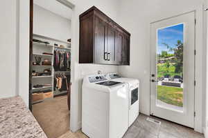 Laundry area featuring cabinet space, washer and dryer, and light carpet