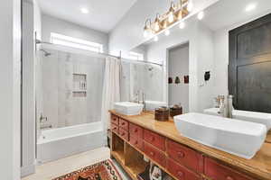 Full bath with shower / bath combo, double vanity, and recessed lighting