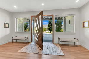 Doorway to outside with recessed lighting and wood finished floors