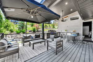 Wooden deck with outdoor dining area, an outdoor living space, and grilling area