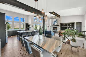 Dining space featuring light wood finished floors, a fireplace, a towering ceiling, recessed lighting, and ceiling fan
