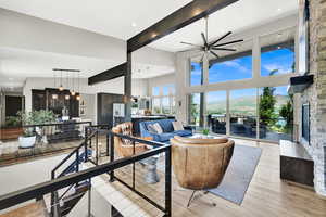 Living room with beamed ceiling, a mountain view, a fireplace, recessed lighting, and light wood-style flooring