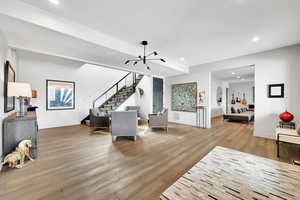 Living room featuring recessed lighting, light wood-type flooring, stairway, and a chandelier