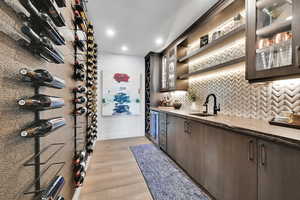 Wine room featuring light wood-type flooring, recessed lighting, and wine cooler
