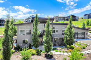 Rear view of house with stone siding and a patio