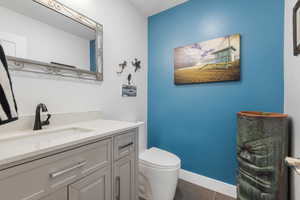 Half bath featuring baseboards and vanity