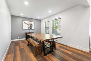 Dining area with dark wood-style flooring and recessed lighting