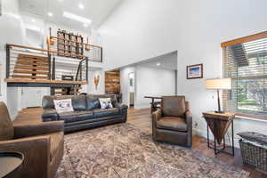Living area with recessed lighting, dark wood finished floors, and a towering ceiling