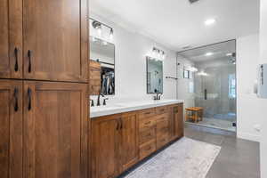 Bathroom with double vanity, a stall shower, recessed lighting, and a spacious closet