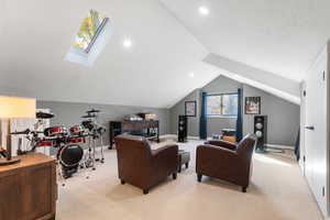 Bedroom 3, with carpet, lofted ceiling, a skylight, and recessed lighting