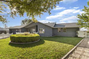 Rear view of house featuring roof with shingles, an attached garage, and a gate