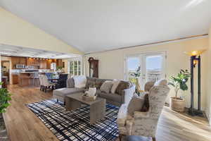 Living area with light wood-style floors, plenty of natural light, and vaulted ceiling