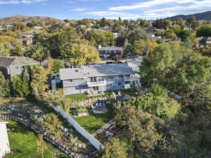 Aerial view of property and surrounding area with a mountainous background and nearby suburban area