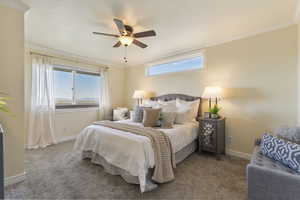 Carpeted bedroom with ornamental molding and ceiling fan