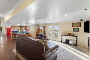 Living room with crown molding, french doors, billiards table, recessed lighting, and a textured ceiling