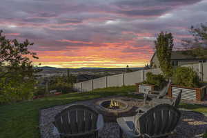 Fenced backyard with an outdoor fire pit, a mountain view, and a patio area