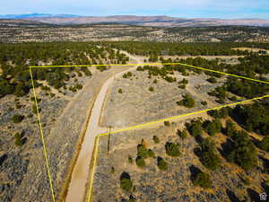 Aerial view of sparsely populated area featuring a mountain backdrop and property parcel outlined
