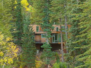 Back of property with a deck and a forest view