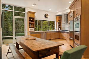 Kitchen featuring open shelves, light wood-style flooring, recessed lighting, appliances with stainless steel finishes, and wall chimney exhaust hood
