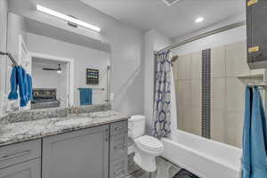 Ensuite bathroom featuring vanity and shower / tub combo with curtain