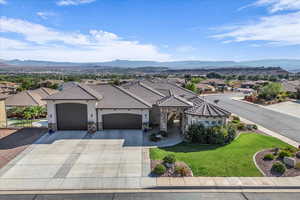 View of front of home featuring stone siding, a garage, a front lawn, a residential view, and driveway