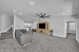 Living room featuring light carpet, stairway, recessed lighting, and ceiling fan