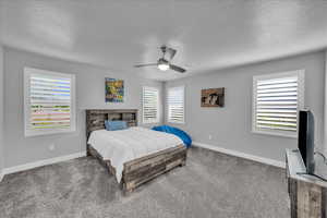 Carpeted bedroom featuring a ceiling fan and a textured ceiling