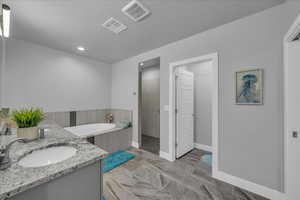 Full bathroom featuring a bath, recessed lighting, vanity, and a tile shower