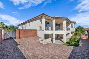 Rear view of house with a fenced backyard, a patio, stucco siding, a gate, and a balcony