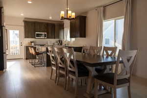 Dining area with a chandelier, light wood-style floors, and recessed lighting