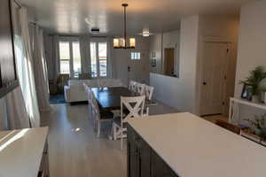 Dining room with light wood-type flooring and a chandelier