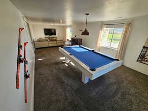 Game room with dark carpet, pool table, and a textured ceiling