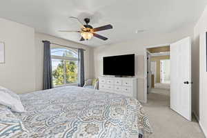 Bedroom featuring light colored carpet and ceiling fan