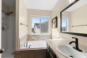 Bathroom with a garden tub, vanity, and a stall shower
