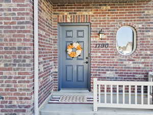 View of exterior entry with brick siding