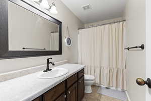 Full bath featuring vanity, curtained shower, and light tile patterned floors