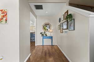 Hallway with dark wood-type flooring and recessed lighting