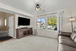 Living area with light colored carpet and baseboards